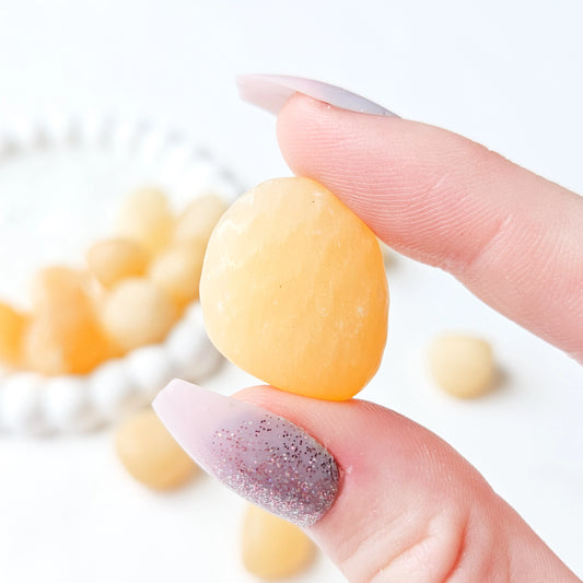 Yellow Calcite Tumbled Stones In Hand